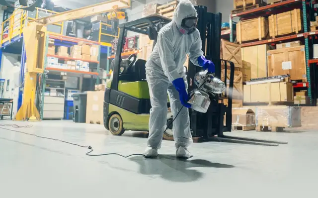 Operatore che pulisce un capannone industriale a Brescia